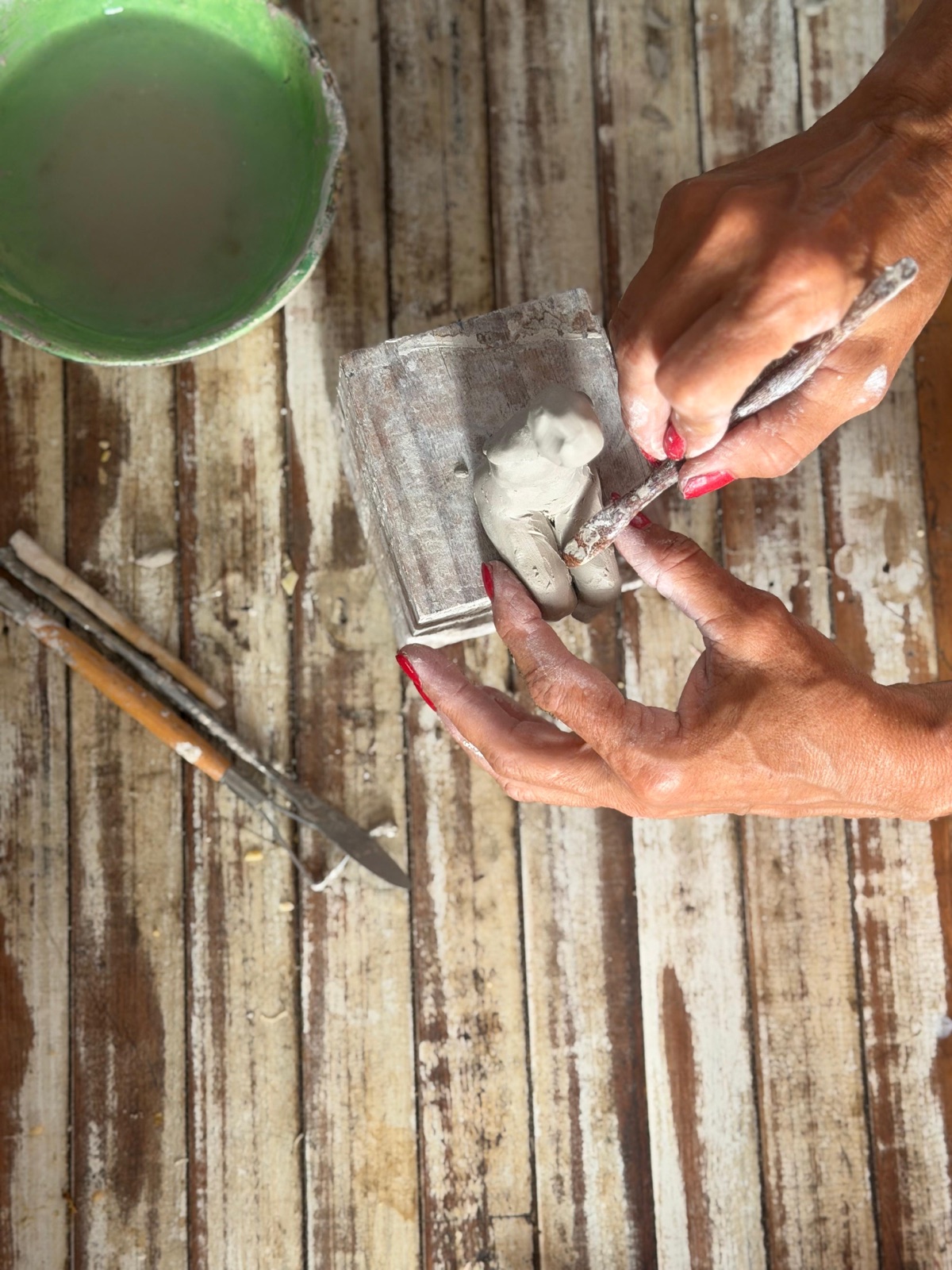 Detalle de manos trabajando una figura pequeña