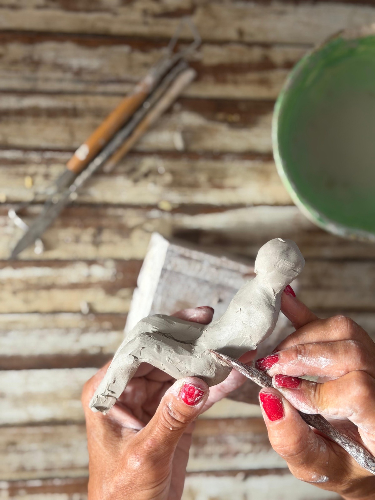 Manos modelando una pequeña figura de arcilla