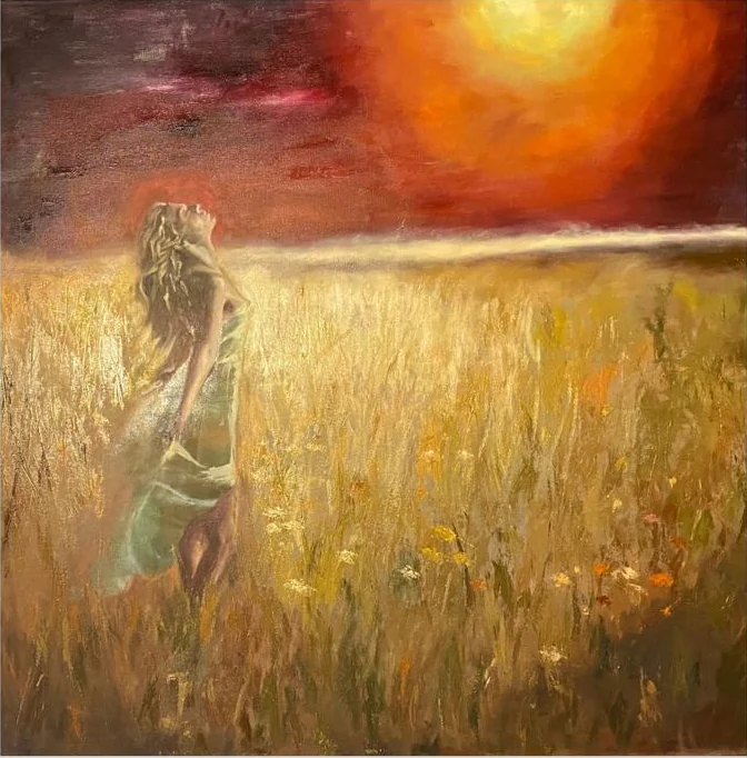 Mujer en un campo dorado bajo un cielo encendido