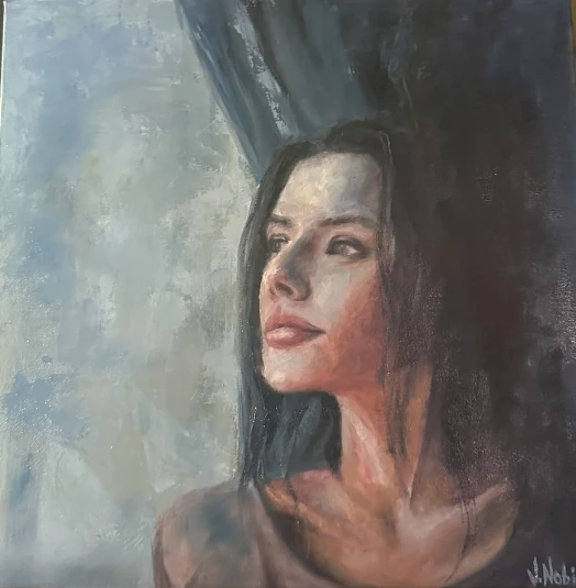 Una mujer de cabello oscuro eleva la mirada junto a un área luminosa de grises y celestes.